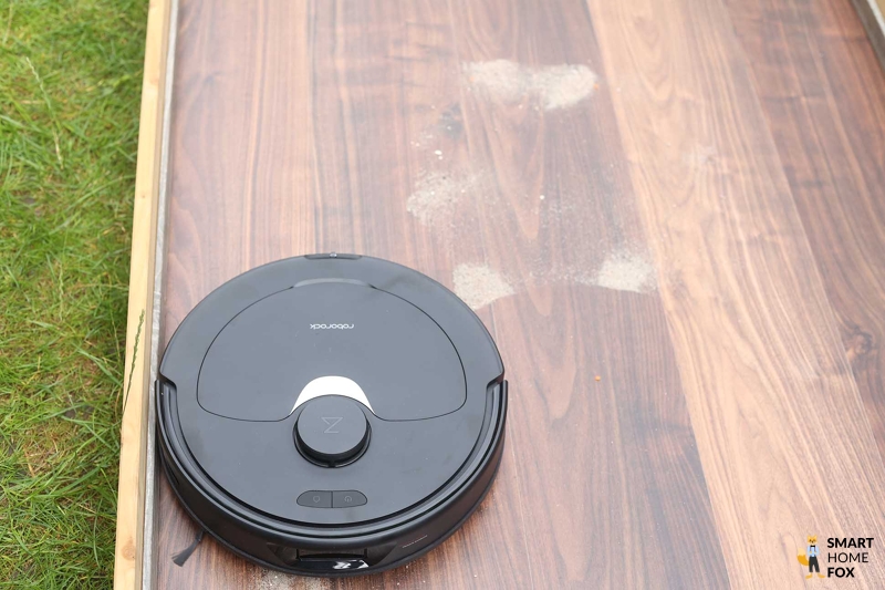 Roborock Q Revo saugt Sand im Saugtest auf dem Laminat.